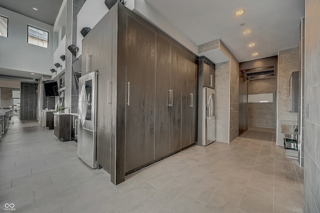 hallway with light tile patterned flooring and tile walls