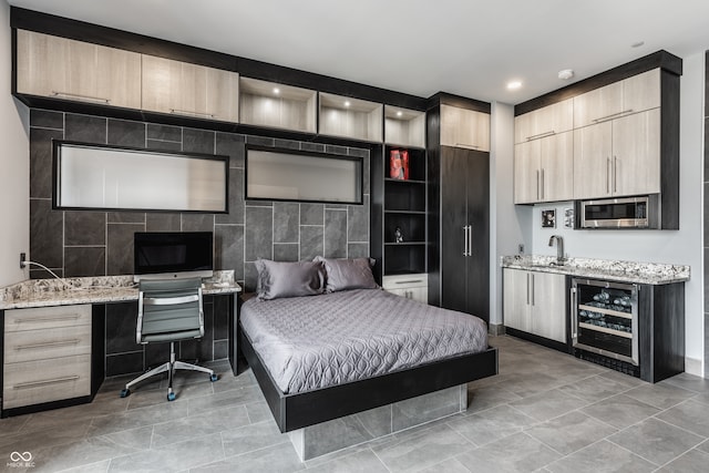 tiled bedroom featuring built in desk, sink, and wine cooler