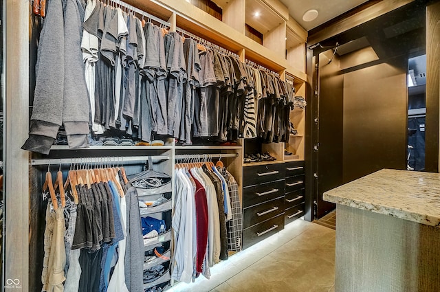 walk in closet with light tile patterned floors