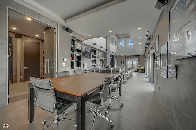 tiled dining space featuring a towering ceiling