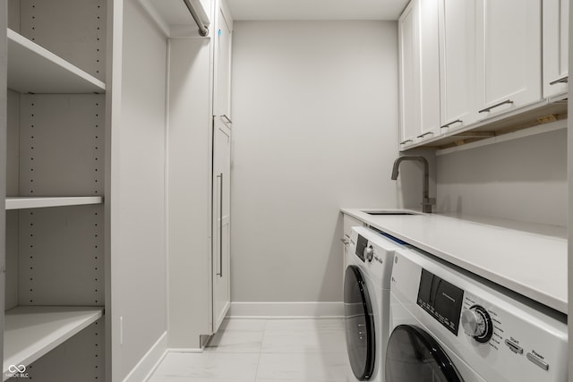 clothes washing area with light tile patterned floors, washer and dryer, sink, and cabinets