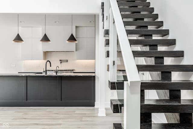 staircase featuring light hardwood / wood-style flooring and sink