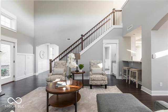 living room featuring dark hardwood / wood-style flooring and a towering ceiling