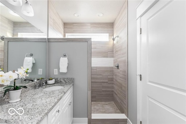 bathroom with vanity and tiled shower