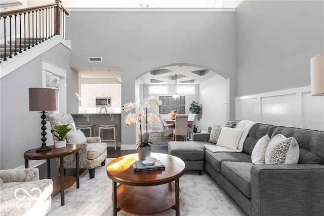 living room featuring light hardwood / wood-style flooring and a high ceiling