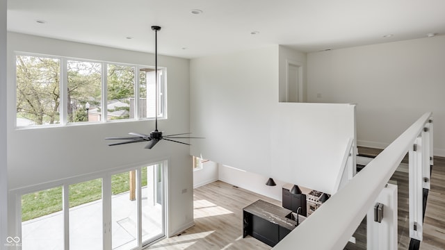 stairs featuring light hardwood / wood-style floors and ceiling fan