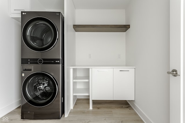 laundry room with light hardwood / wood-style flooring and stacked washer and dryer