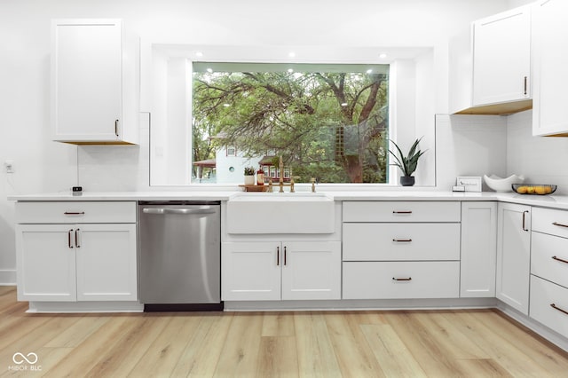 kitchen with light wood-type flooring, sink, white cabinetry, backsplash, and stainless steel dishwasher