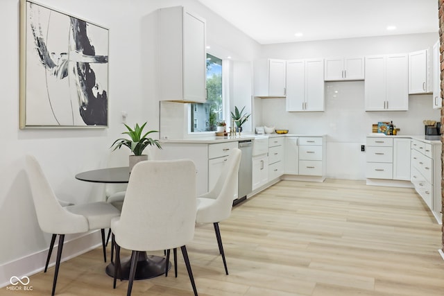 kitchen featuring white cabinetry, light hardwood / wood-style floors, and stainless steel dishwasher