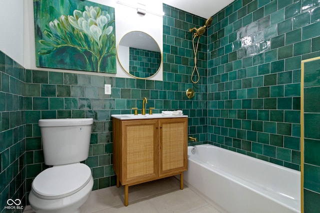 full bathroom featuring tile patterned flooring, toilet, vanity, tile walls, and tiled shower / bath