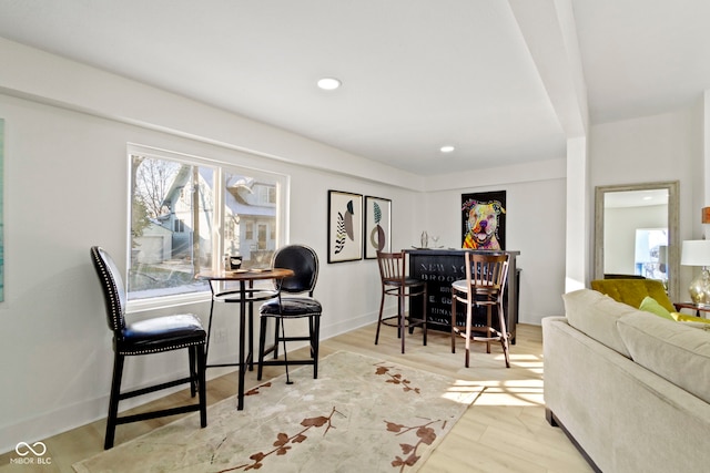 dining area with indoor bar and light hardwood / wood-style flooring