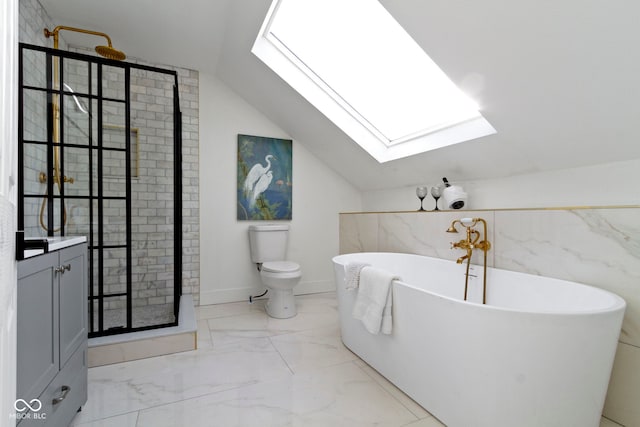 bathroom featuring a washtub, lofted ceiling with skylight, toilet, vanity, and tile walls