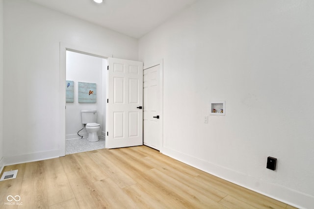 2936 N New Jersey St, Indianapolis, IN 46205 - unfurnished bedroom with light wood-type flooring, baseboards, and connected bathroom