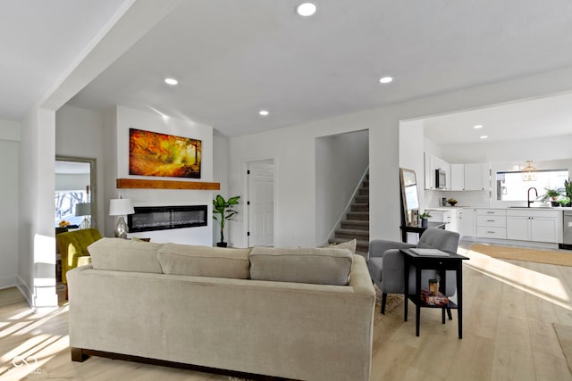 2936 N New Jersey St, Indianapolis, IN 46205 - living room with stairs, a glass covered fireplace, light wood-style flooring, and recessed lighting