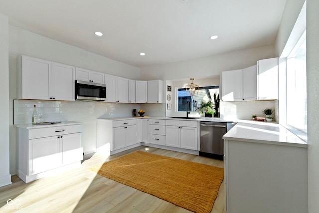 2936 N New Jersey St, Indianapolis, IN 46205 - kitchen with stainless steel appliances, light wood-style flooring, tasteful backsplash, a sink, and recessed lighting