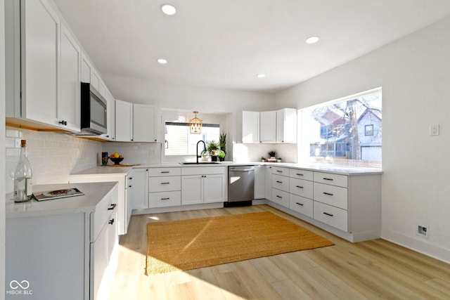 2936 N New Jersey St, Indianapolis, IN 46205 - kitchen with appliances with stainless steel finishes, a sink, light wood finished floors, decorative backsplash, and white cabinets