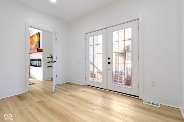 2936 N New Jersey St, Indianapolis, IN 46205 - doorway with french doors, wood finished floors, a glass covered fireplace, and baseboards