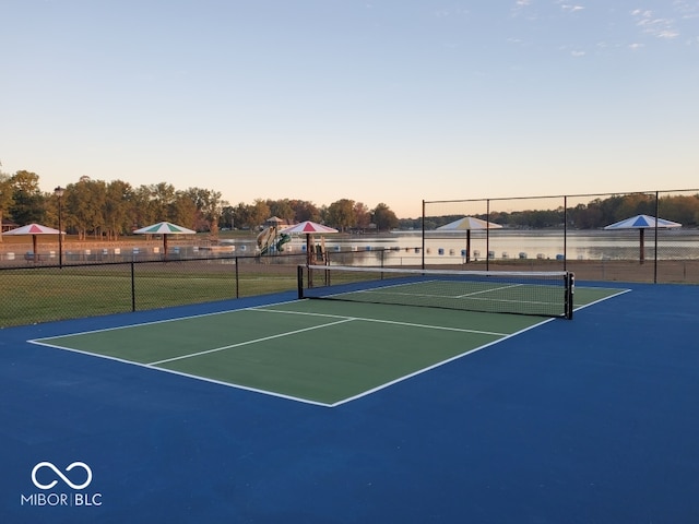 view of tennis court with basketball court and a water view