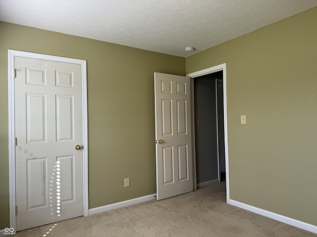 unfurnished bedroom with light carpet and a textured ceiling