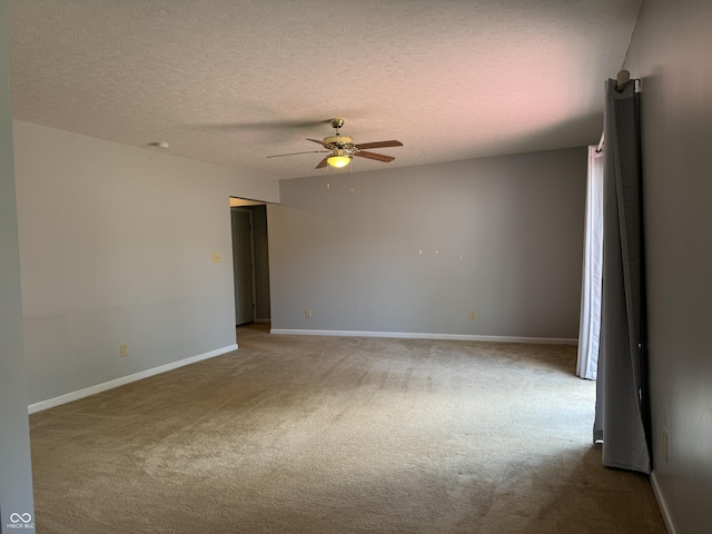 carpeted spare room featuring a textured ceiling and ceiling fan