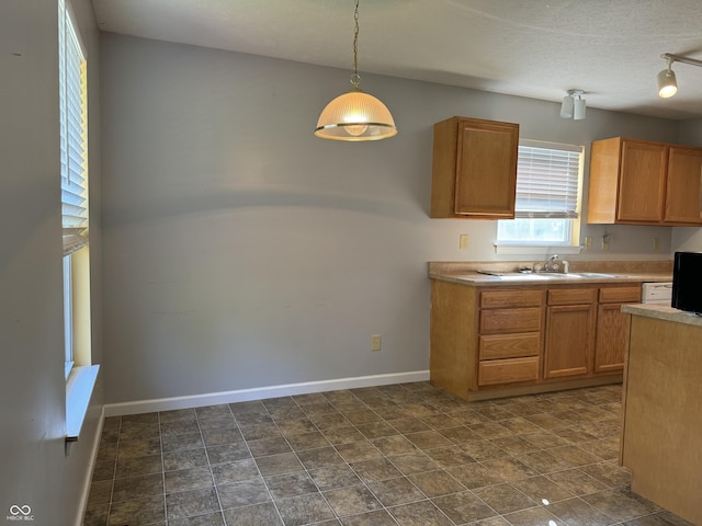 kitchen with sink, hanging light fixtures, and a textured ceiling