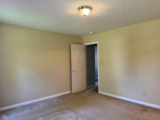 unfurnished room featuring carpet and a textured ceiling