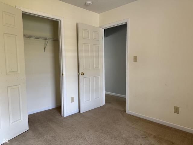 unfurnished bedroom with a closet and carpet flooring