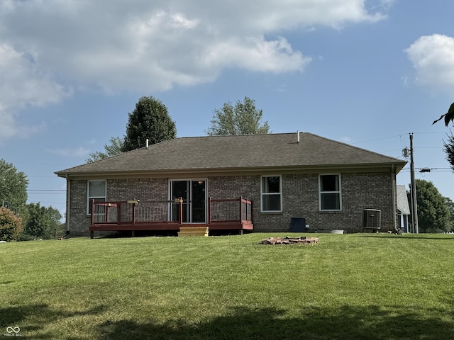 rear view of house with a wooden deck, central AC, and a lawn