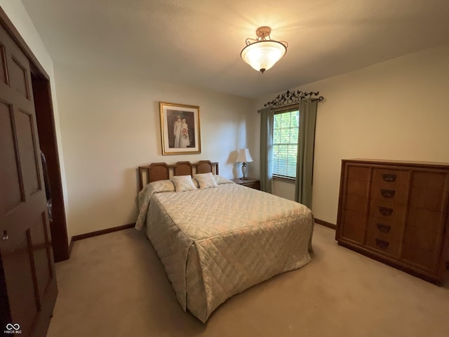 bedroom featuring light carpet and baseboards