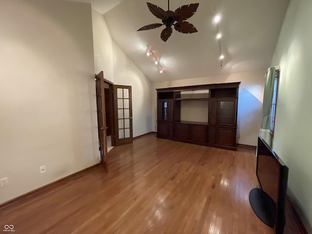 interior space featuring high vaulted ceiling, rail lighting, ceiling fan, and light wood finished floors