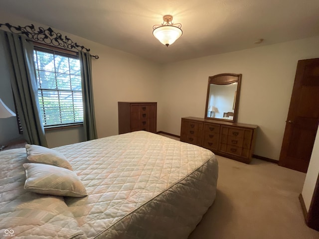 bedroom with light carpet and baseboards