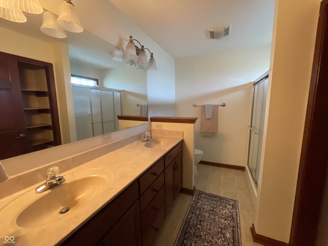 bathroom featuring toilet, dual bowl vanity, and tile patterned floors