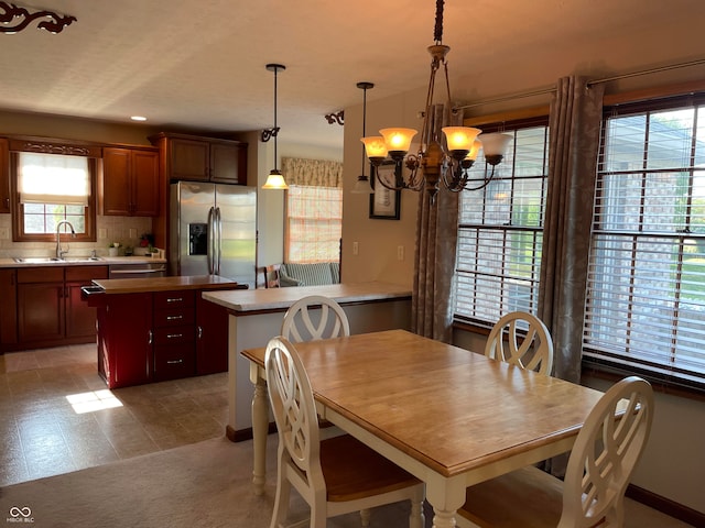 dining room with light tile patterned floors, sink, and an inviting chandelier