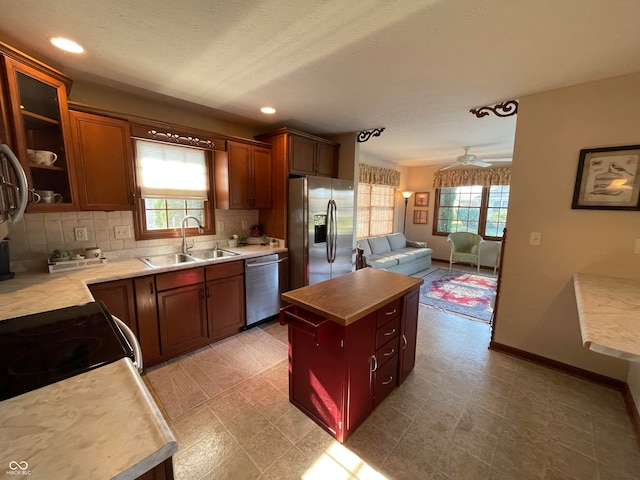 kitchen with stainless steel appliances, ceiling fan, sink, tasteful backsplash, and light tile patterned flooring