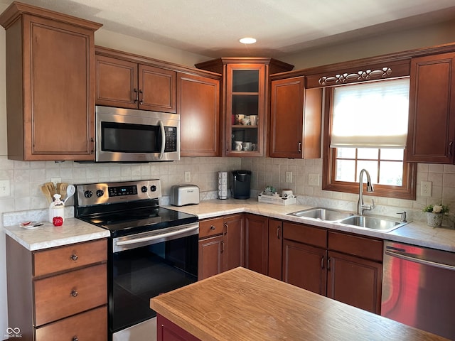 kitchen with decorative backsplash, appliances with stainless steel finishes, and sink