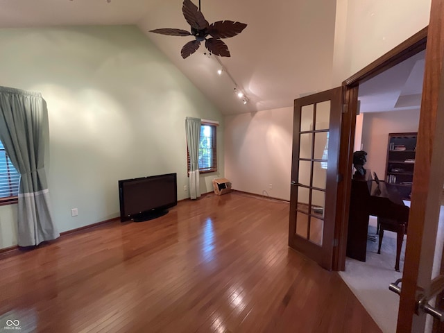 interior space featuring ceiling fan, track lighting, wood-type flooring, and high vaulted ceiling