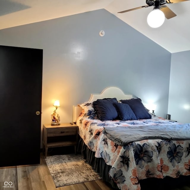 bedroom with light hardwood / wood-style floors, vaulted ceiling, and ceiling fan