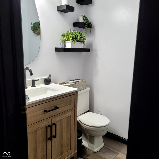 bathroom featuring vanity, toilet, and hardwood / wood-style floors