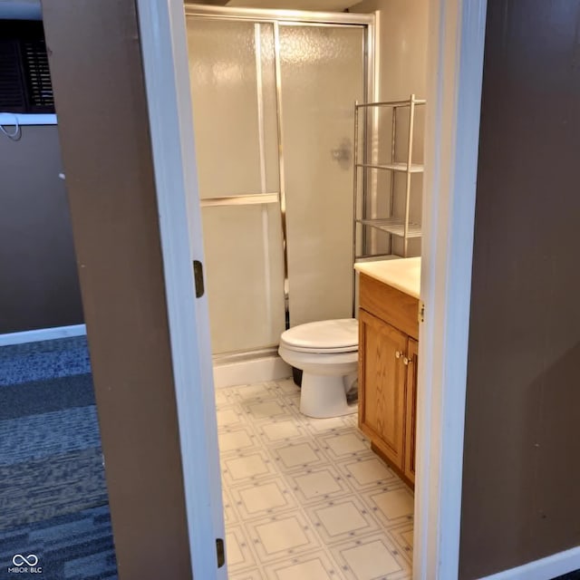 bathroom featuring tile patterned floors, vanity, an enclosed shower, and toilet