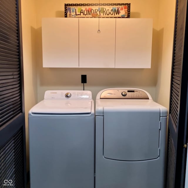 washroom with washer and clothes dryer and cabinets