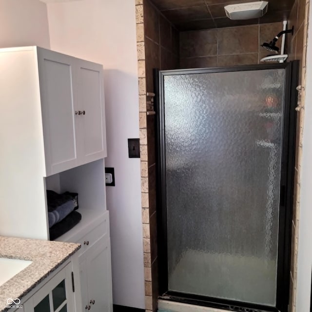 bathroom with a shower with door and vanity