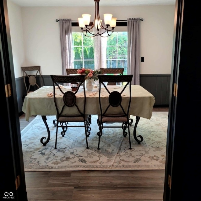 dining area featuring hardwood / wood-style floors and an inviting chandelier