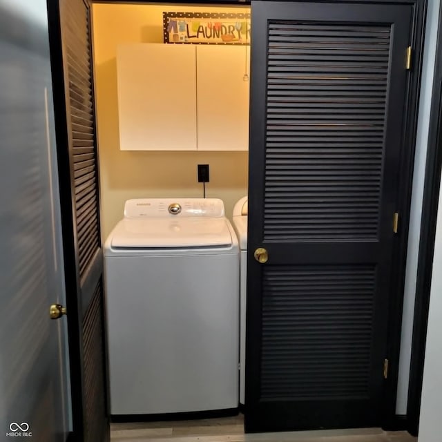 washroom featuring separate washer and dryer and cabinets