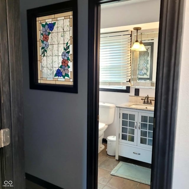 bathroom featuring vanity, toilet, tile patterned floors, and a healthy amount of sunlight