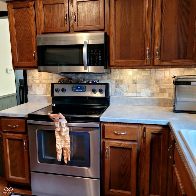 kitchen with appliances with stainless steel finishes and backsplash