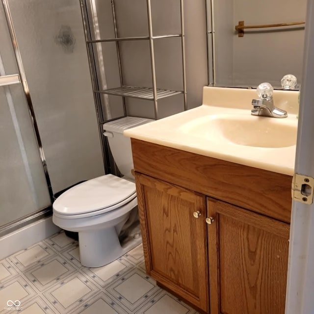 bathroom with vanity, walk in shower, tile patterned flooring, and toilet