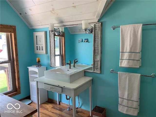 bathroom with hardwood / wood-style flooring, vaulted ceiling, and sink