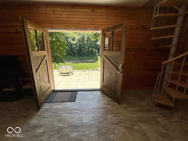 doorway to outside with wooden walls