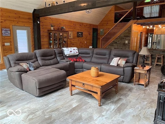 living room featuring lofted ceiling with beams and wooden walls