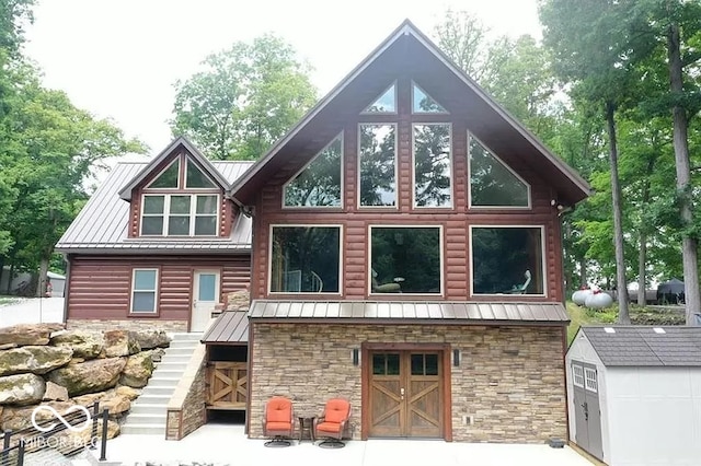 rear view of house with a storage shed